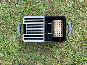top view of a half grill shown fitted to a weber GA with a chimney starter on a grass background