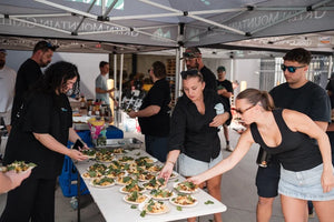 BBQ class participants serving themselves smoked meats at an outdoor Firehouse Barbecue event