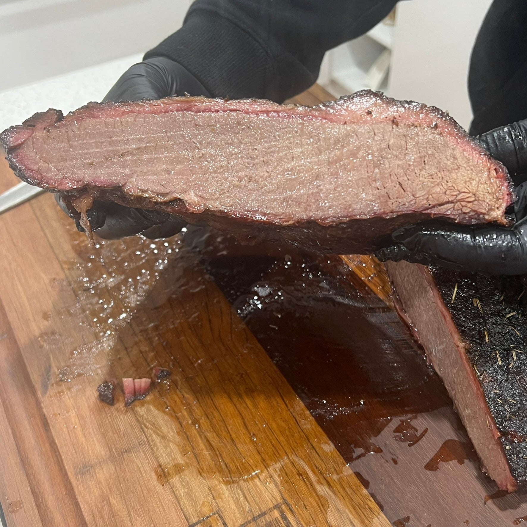 Cooked juicy brisket cut in half over a chopping board