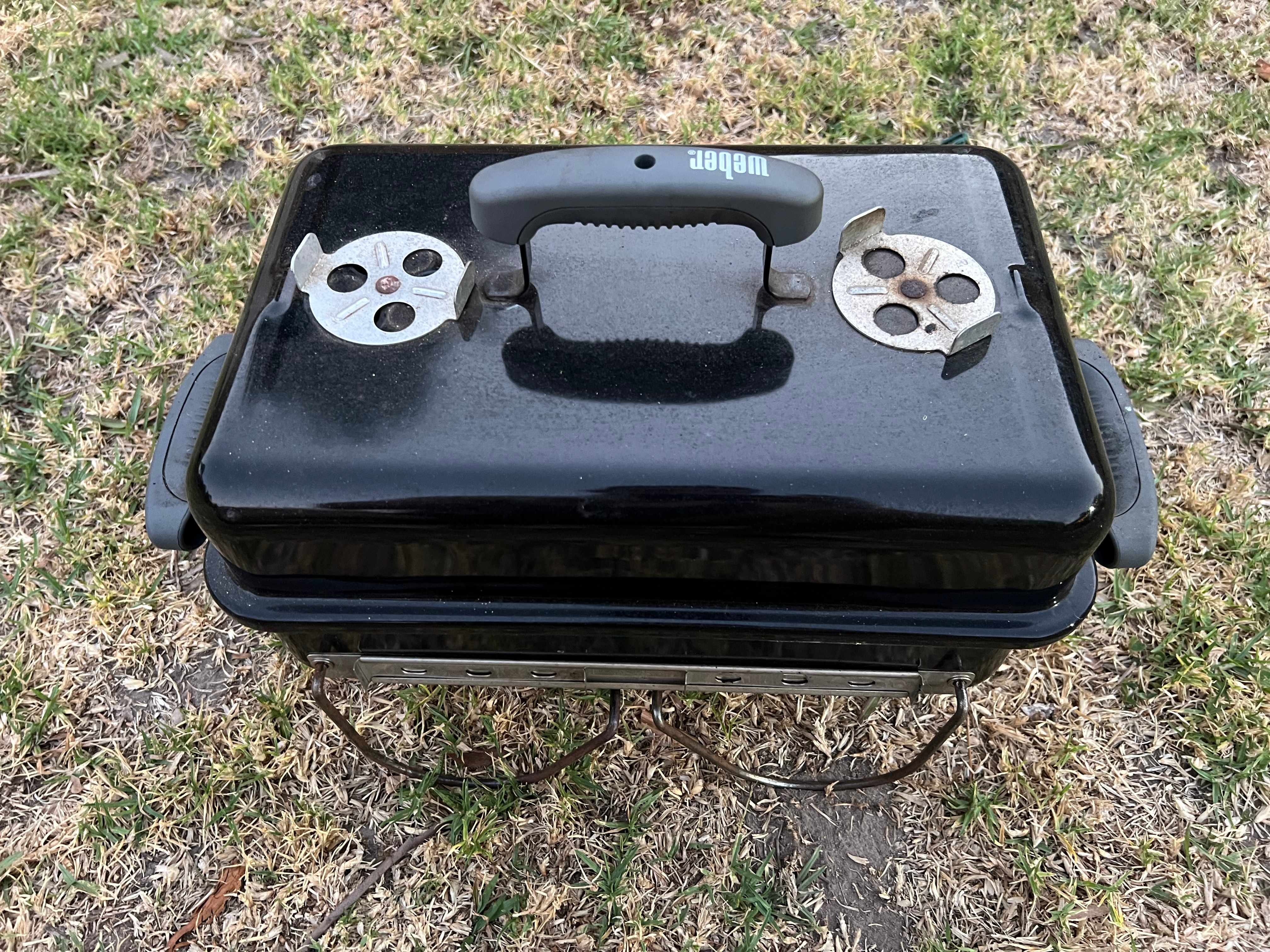 Weber GA with grass background, lid on and all parts inside
