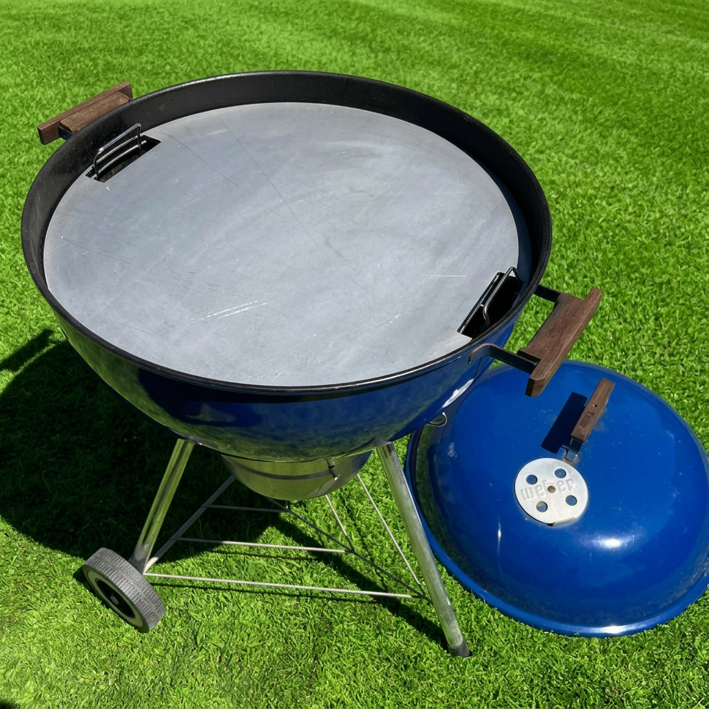 Barbecue grill with a blue lid on a grassy area
