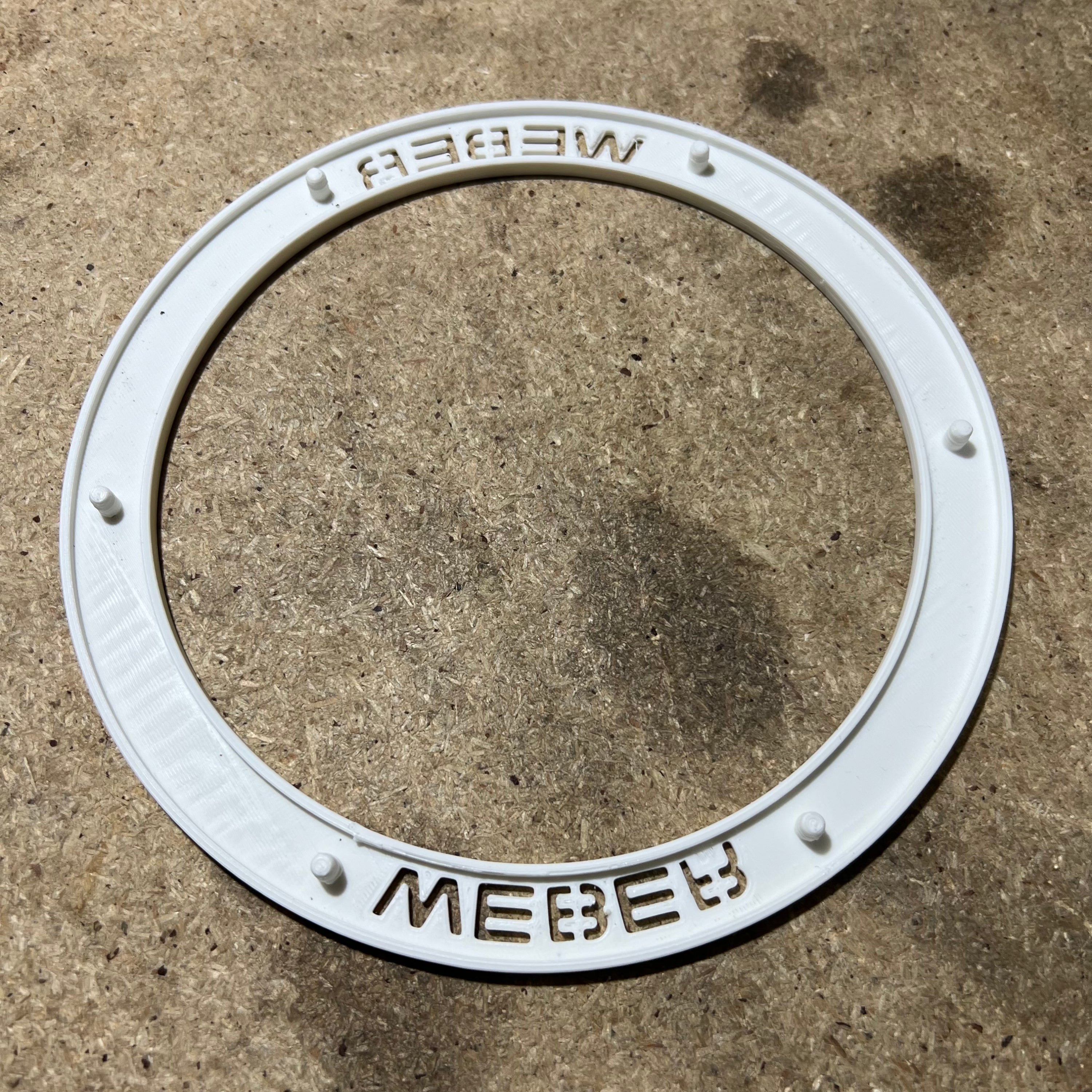 Backside of a wheel insert showing the raised edges sitting on a bench
