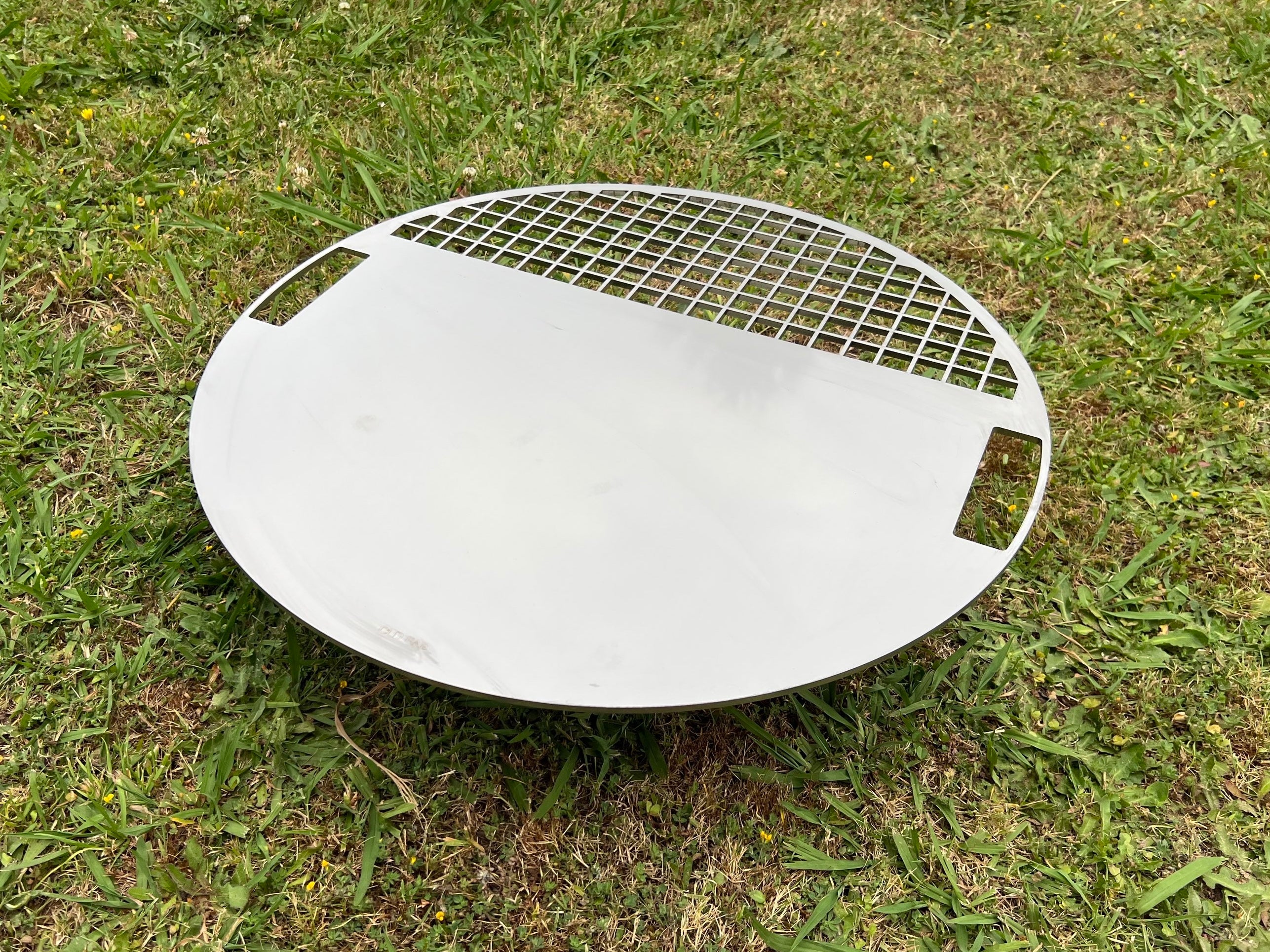Angled view of the Stainless Plate with green grass background