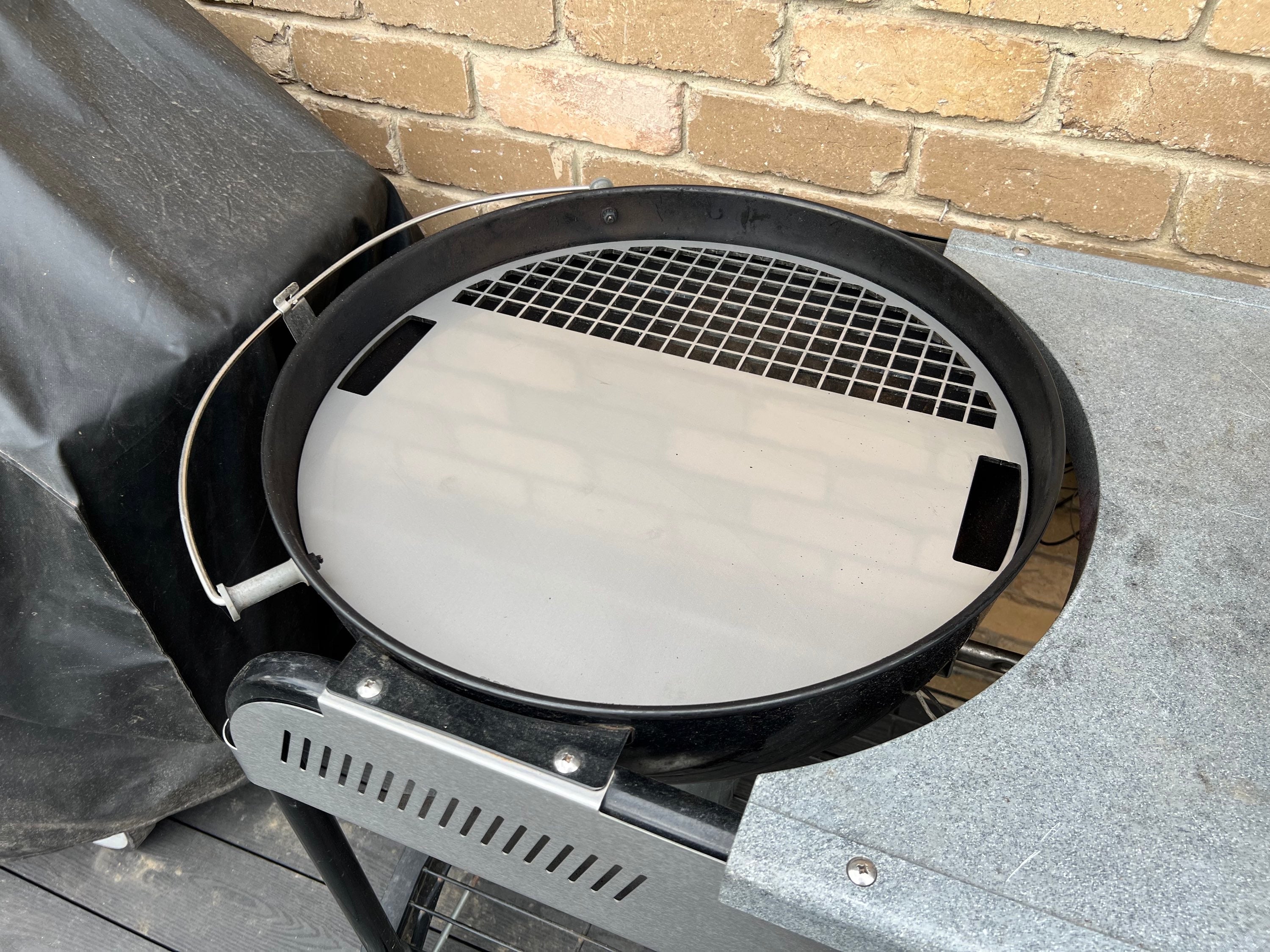 Angled view of the grill plate fitted to a weber kettle