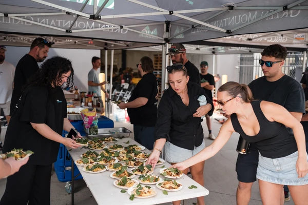 BBQ class participants serving themselves smoked meats at an outdoor Firehouse Barbecue event