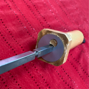 Wooden tool with a metal blade on a red textured background